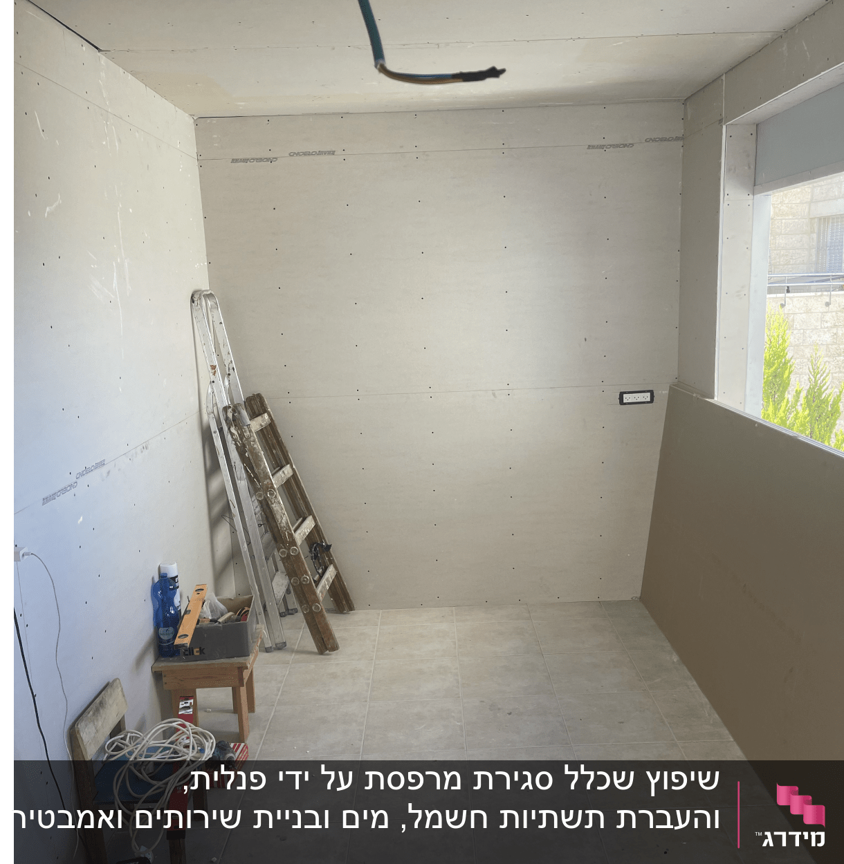 חדר בבנייה עם סולם, כבלים וכלי עבודה